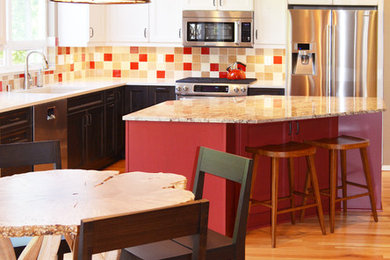 Eat-in kitchen - mid-sized eclectic l-shaped light wood floor eat-in kitchen idea in Seattle with an undermount sink, shaker cabinets, white cabinets, granite countertops, multicolored backsplash, ceramic backsplash, stainless steel appliances and an island