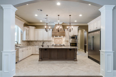 This is an example of a large u-shaped enclosed kitchen in New Orleans with a submerged sink, recessed-panel cabinets, white cabinets, multi-coloured splashback, mosaic tiled splashback, stainless steel appliances, marble flooring, an island, quartz worktops, beige floors and beige worktops.