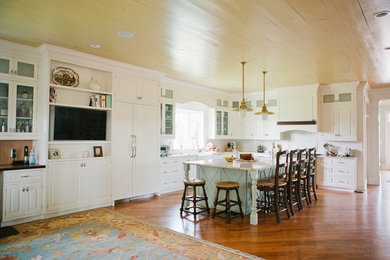 Large mountain style l-shaped medium tone wood floor eat-in kitchen photo in Other with a double-bowl sink, white cabinets, granite countertops, white backsplash, paneled appliances and an island