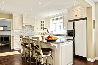 Example of a mid-sized l-shaped dark wood floor kitchen design in Toronto with an undermount sink, raised-panel cabinets, white cabinets, quartz countertops and an island