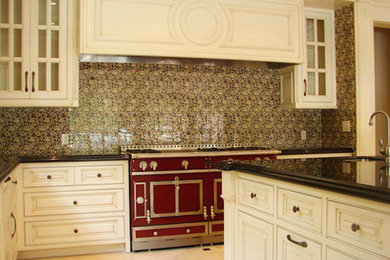 Exempel på ett stort kök, med en undermonterad diskho, luckor med infälld panel, vita skåp, rostfria vitvaror och en köksö