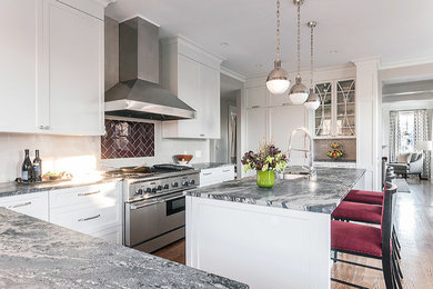 Inspiration for a mid-sized transitional l-shaped dark wood floor and brown floor eat-in kitchen remodel in Boston with an undermount sink, recessed-panel cabinets, white cabinets, white backsplash, subway tile backsplash, paneled appliances, an island and gray countertops