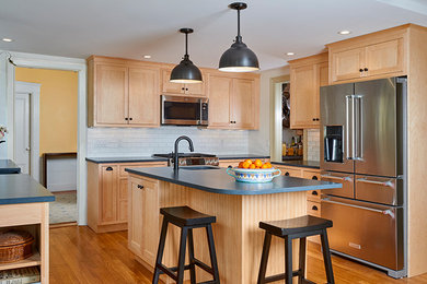 Inspiration for a mid-sized cottage single-wall medium tone wood floor and brown floor enclosed kitchen remodel in Boston with a farmhouse sink, shaker cabinets, light wood cabinets, soapstone countertops, white backsplash, subway tile backsplash, stainless steel appliances, an island and gray countertops