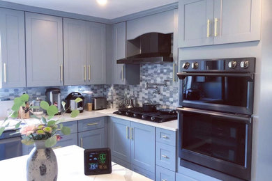 Example of a mid-sized classic l-shaped eat-in kitchen design in Boston with an undermount sink, shaker cabinets, blue cabinets, quartzite countertops, blue backsplash, an island and white countertops