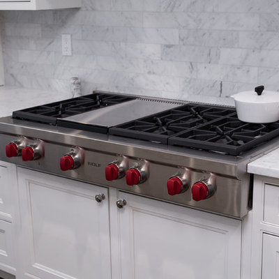 Inspiration for a huge timeless l-shaped dark wood floor and brown floor eat-in kitchen remodel in Boston with an undermount sink, beaded inset cabinets, white cabinets, marble countertops, gray backsplash, marble backsplash, stainless steel appliances, an island and white countertops