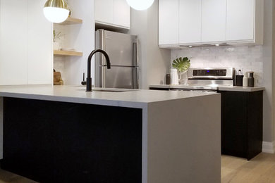 Example of a small minimalist u-shaped light wood floor open concept kitchen design with an undermount sink, flat-panel cabinets, white cabinets, quartz countertops, white backsplash, marble backsplash, stainless steel appliances, a peninsula and gray countertops
