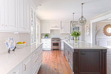 Inspiration for a large contemporary galley medium tone wood floor eat-in kitchen remodel in Toronto with an island, beaded inset cabinets, white cabinets, granite countertops, white backsplash, ceramic backsplash, stainless steel appliances and a drop-in sink