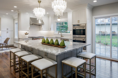 Inspiration for a mid-sized transitional u-shaped medium tone wood floor and brown floor eat-in kitchen remodel in Other with an undermount sink, shaker cabinets, white cabinets, marble countertops, white backsplash, ceramic backsplash, stainless steel appliances, an island and gray countertops