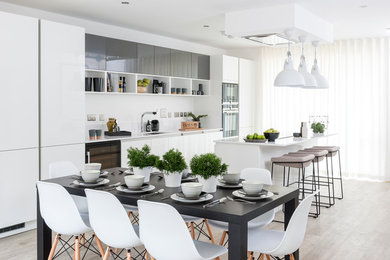 Einzeilige, Mittelgroße Moderne Wohnküche mit Unterbauwaschbecken, Küchenrückwand in Weiß, hellem Holzboden, Kücheninsel, flächenbündigen Schrankfronten und weißen Schränken in Hampshire
