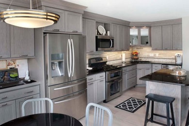 Example of a mid-sized beach style l-shaped light wood floor eat-in kitchen design in Philadelphia with an undermount sink, recessed-panel cabinets, gray cabinets, granite countertops, multicolored backsplash, glass tile backsplash, stainless steel appliances and an island