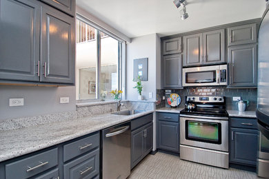 Small transitional l-shaped vinyl floor and beige floor enclosed kitchen photo in San Francisco with an undermount sink, raised-panel cabinets, gray cabinets, granite countertops, gray backsplash, ceramic backsplash, stainless steel appliances and no island