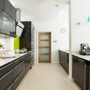 Idee per una grande cucina design con ante lisce, paraspruzzi verde, paraspruzzi con lastra di vetro, 2 o più isole, lavello integrato, ante grigie, top in quarzite, elettrodomestici da incasso e pavimento in gres porcellanato