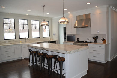 Eat-in kitchen - traditional l-shaped dark wood floor eat-in kitchen idea in Indianapolis with a farmhouse sink, recessed-panel cabinets, white cabinets, marble countertops, white backsplash, ceramic backsplash and an island