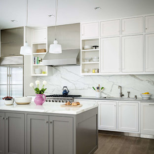 Transitional kitchen ideas - Inspiration for a transitional medium tone wood floor kitchen remodel in San Francisco with an undermount sink, shaker cabinets, white cabinets, white backsplash, stainless steel appliances, an island and marble backsplash