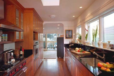 Enclosed kitchen - mid-sized modern galley medium tone wood floor enclosed kitchen idea in San Francisco with an undermount sink, recessed-panel cabinets, medium tone wood cabinets, granite countertops, stone slab backsplash and stainless steel appliances