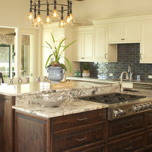 This is an example of a large beach style open plan kitchen in Tampa with an undermount sink, recessed-panel cabinets, white cabinets, granite benchtops, blue splashback, subway tile splashback, stainless steel appliances, dark hardwood floors, with island and brown floor.