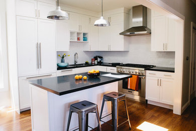 Mid-sized transitional l-shaped medium tone wood floor eat-in kitchen photo in San Francisco with an undermount sink, recessed-panel cabinets, white cabinets, quartzite countertops, ceramic backsplash, paneled appliances and an island