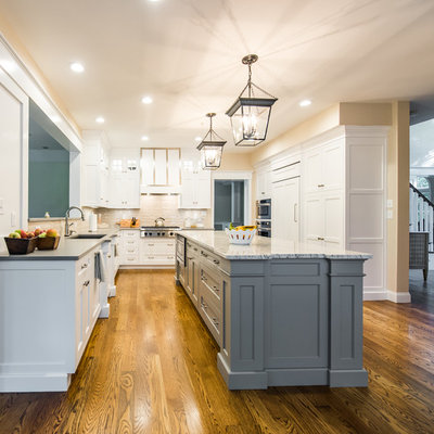 Mid-sized elegant dark wood floor enclosed kitchen photo in Boston with an undermount sink, shaker cabinets, stainless steel appliances, an island, white cabinets, granite countertops, beige backsplash and porcelain backsplash