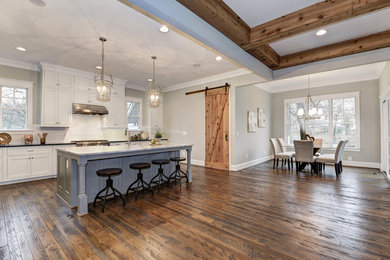 Inspiration for a large craftsman l-shaped dark wood floor open concept kitchen remodel in DC Metro with a drop-in sink, flat-panel cabinets, white cabinets, granite countertops, white backsplash, subway tile backsplash, stainless steel appliances and an island
