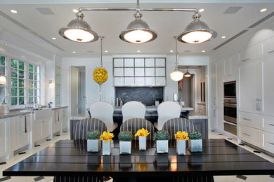 Eat-in kitchen - traditional u-shaped eat-in kitchen idea in Miami with a farmhouse sink, raised-panel cabinets, white cabinets, marble countertops, gray backsplash and paneled appliances