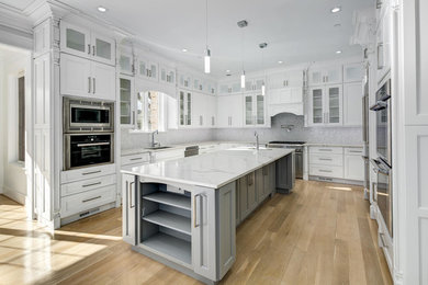 Mid-sized minimalist u-shaped light wood floor and beige floor open concept kitchen photo in DC Metro with an undermount sink, shaker cabinets, white cabinets, marble countertops, gray backsplash, mosaic tile backsplash, stainless steel appliances and an island