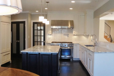 Example of a large transitional l-shaped dark wood floor open concept kitchen design in DC Metro with an undermount sink, shaker cabinets, white cabinets, marble countertops, white backsplash, subway tile backsplash, stainless steel appliances and an island