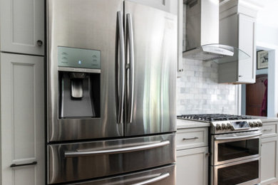Example of a mid-sized classic l-shaped porcelain tile and brown floor open concept kitchen design in Newark with an undermount sink, shaker cabinets, gray cabinets, quartz countertops, gray backsplash, porcelain backsplash, stainless steel appliances, an island and white countertops