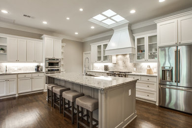 Eat-in kitchen - large transitional u-shaped dark wood floor eat-in kitchen idea in Dallas with an undermount sink, recessed-panel cabinets, white cabinets, granite countertops, beige backsplash, ceramic backsplash, stainless steel appliances and an island