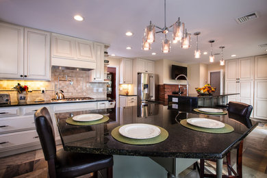 Large transitional galley eat-in kitchen photo in New York with recessed-panel cabinets, beige cabinets, ceramic backsplash, a double-bowl sink, quartz countertops, white backsplash, stainless steel appliances and an island