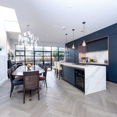 Eat-in kitchen - mid-sized contemporary single-wall light wood floor and beige floor eat-in kitchen idea in London with flat-panel cabinets, blue cabinets, marble countertops, white backsplash, marble backsplash, an island and white countertops