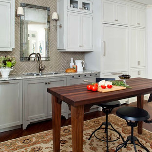 Large elegant medium tone wood floor enclosed kitchen photo in Atlanta with recessed-panel cabinets, gray cabinets, paneled appliances, an undermount sink, marble countertops, gray backsplash, subway tile backsplash and an island