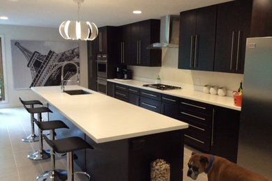 ミネアポリスにある広いコンテンポラリースタイルのおしゃれなキッチン (フラットパネル扉のキャビネット、濃色木目調キャビネット、白いキッチンパネル、シルバーの調理設備) の写真