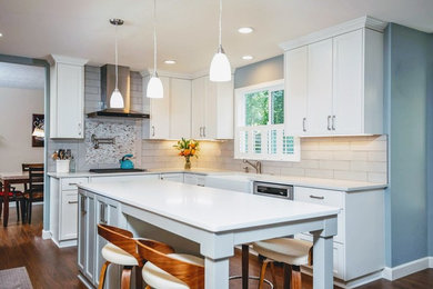 Inspiration for a mid-sized timeless l-shaped vinyl floor and brown floor eat-in kitchen remodel in Portland with a farmhouse sink, shaker cabinets, white cabinets, quartzite countertops, gray backsplash, subway tile backsplash, stainless steel appliances, an island and white countertops