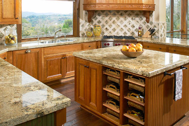 Example of a large mountain style u-shaped medium tone wood floor kitchen design in Sacramento with a double-bowl sink, recessed-panel cabinets, medium tone wood cabinets, granite countertops, beige backsplash, stone tile backsplash, stainless steel appliances and an island