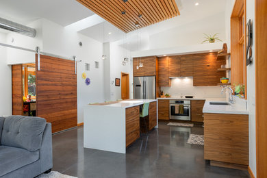 Open concept kitchen - small contemporary l-shaped concrete floor and gray floor open concept kitchen idea in Other with an undermount sink, medium tone wood cabinets, white backsplash, stainless steel appliances, an island, white countertops, flat-panel cabinets and ceramic backsplash