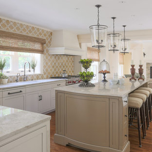 Photo of a traditional l-shaped open plan kitchen in Boston with a single-bowl sink, beaded inset cabinets, white cabinets, multi-coloured splashback, stainless steel appliances, medium hardwood floors and with island.