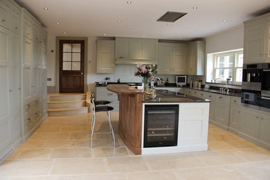 Photo of a large contemporary u-shaped kitchen/diner in West Midlands with a submerged sink, beaded cabinets, granite worktops, grey splashback, glass sheet splashback, stainless steel appliances, travertine flooring and an island.