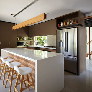 Idee per una grande cucina a L minimal con ante lisce, ante marroni, elettrodomestici in acciaio inossidabile e isola