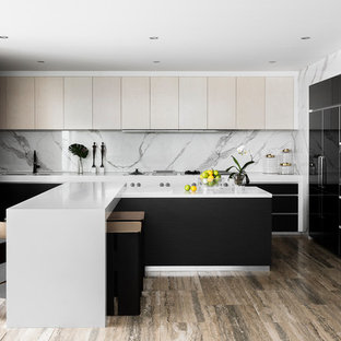 Design ideas for a contemporary l-shaped kitchen in Melbourne with an undermount sink, flat-panel cabinets, beige cabinets, white splashback, panelled appliances, with island, brown floor and white benchtop.