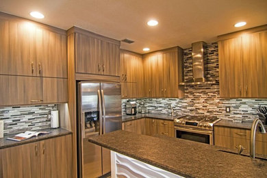 Example of a mid-sized trendy l-shaped porcelain tile eat-in kitchen design in Tampa with a double-bowl sink, flat-panel cabinets, granite countertops, multicolored backsplash, glass tile backsplash, stainless steel appliances, an island and medium tone wood cabinets