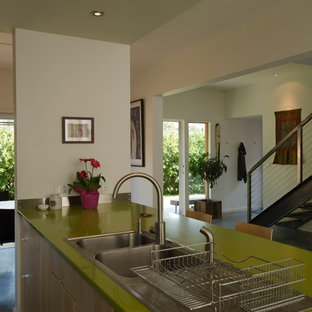 This is an example of a small modern single-wall eat-in kitchen in Other with a drop-in sink, flat-panel cabinets, light wood cabinets, quartz benchtops, stainless steel appliances, concrete floors, with island and green benchtop.