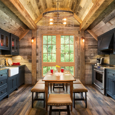 Mountain style galley medium tone wood floor and brown floor eat-in kitchen photo in Minneapolis with a farmhouse sink, quartzite countertops, paneled appliances, shaker cabinets, black cabinets and no island
