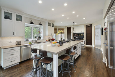 Large urban u-shaped dark wood floor and brown floor eat-in kitchen photo in Chicago with an undermount sink, recessed-panel cabinets, white cabinets, quartzite countertops, white backsplash, cement tile backsplash, stainless steel appliances, an island and beige countertops