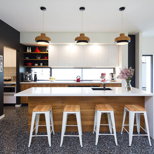 Photo of a mid-sized contemporary galley open plan kitchen in Brisbane with an undermount sink, medium wood cabinets, quartz benchtops, multi-coloured splashback, window splashback, stainless steel appliances, concrete floors, with island, flat-panel cabinets and grey floor.