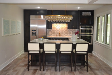 Mid-sized transitional galley medium tone wood floor and brown floor eat-in kitchen photo in Detroit with an undermount sink, shaker cabinets, dark wood cabinets, quartz countertops, white backsplash, stone tile backsplash, stainless steel appliances and an island