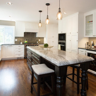 Example of a large classic u-shaped medium tone wood floor open concept kitchen design in Portland with an undermount sink, beaded inset cabinets, white cabinets, quartz countertops, beige backsplash, glass tile backsplash, stainless steel appliances, an island and black countertops