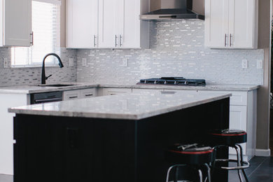 Cette image montre une cuisine américaine design avec un placard à porte shaker, des portes de placard blanches, un plan de travail en granite, une crédence blanche, une crédence en mosaïque et îlot.
