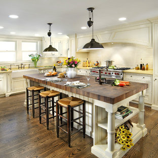 Idee per una cucina tradizionale con elettrodomestici in acciaio inossidabile, lavello stile country, top in legno e top giallo