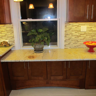 Small traditional l-shaped kitchen pantry in New York with shaker cabinets, light wood cabinets, granite benchtops, beige splashback, glass tile splashback, stainless steel appliances, porcelain floors and no island.