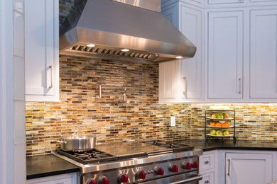 Inspiration for a large u-shaped medium tone wood floor eat-in kitchen remodel in Detroit with an undermount sink, beaded inset cabinets, white cabinets, granite countertops, glass tile backsplash, stainless steel appliances and an island
